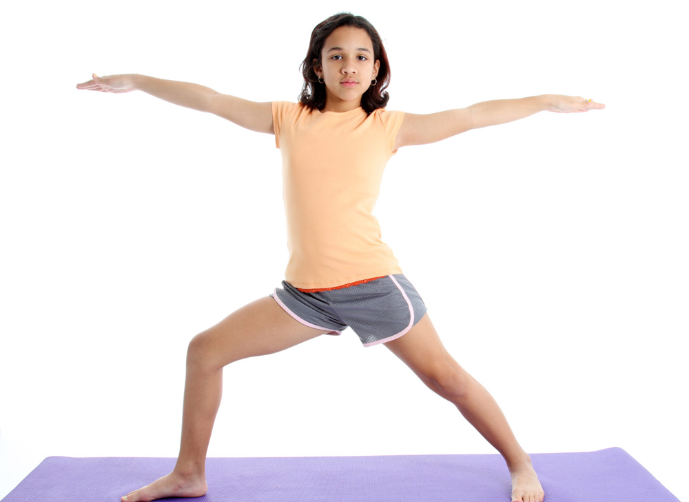 A girl holding a yoga warrior pose